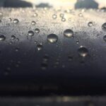Water beads on ceramic coated paint on vehicles hood sun shining in the reflection