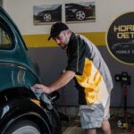 Owner of Horizon Detail leveling a ceramic coating on a 1928 Dodge Brothers