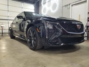 Black Cadillac CT5 Full Paint Correction and Ceramic Coating under the shop lights