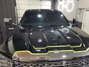 Danny's Duramax Paint Correction - Hood Under The Shop Lights Prior To Ceramic Coating in Northwest Indiana